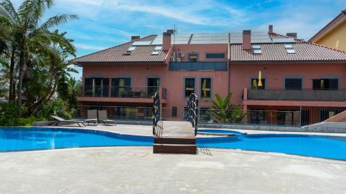 a house with a swimming pool in front of a building at Deluxe Living by LovelyStay in Funchal