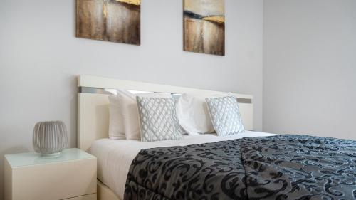 a bedroom with a bed and two paintings on the wall at Deluxe Living by LovelyStay in Funchal