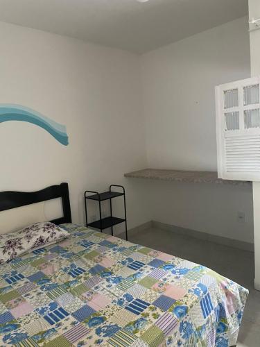 a bedroom with a bed with a quilt on it at Hostel Farol da Barra in Salvador