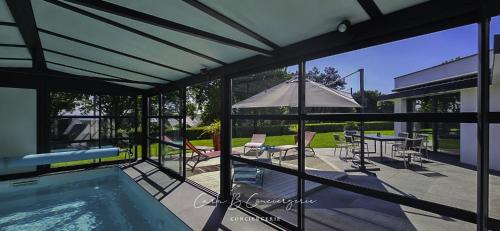 une maison avec une piscine et un parasol dans l'établissement PERLE Maison contenporaine avec piscine 6 pers, à Concarneau