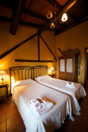 a bedroom with a large bed with white sheets at El Rincón de Castilla in Puerto de Béjar