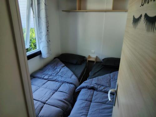 une chambre avec deux lits et une fenêtre dans l'établissement Mobilhome La Réserve - 3 ch - 6 pers - Terrasse, à Gastes