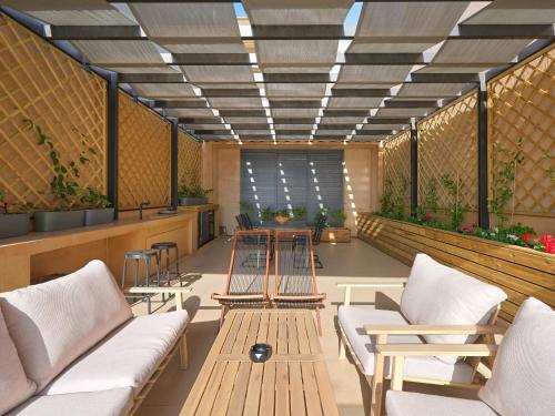 a waiting room with benches and tables and plants at Sea View Garden Suites in Piraeus