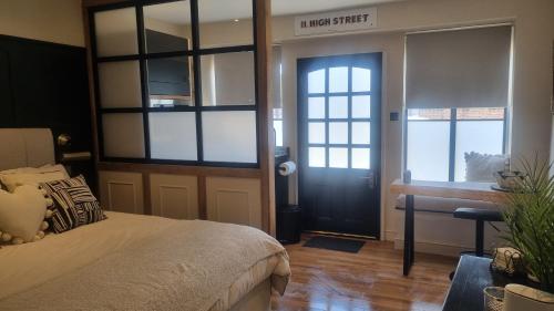 a bedroom with a bed and a desk and a door at The Old Shop High Street in Llanidloes