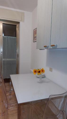 a kitchen with a white table and some chairs at Casa vacanza PASsaggio in Como