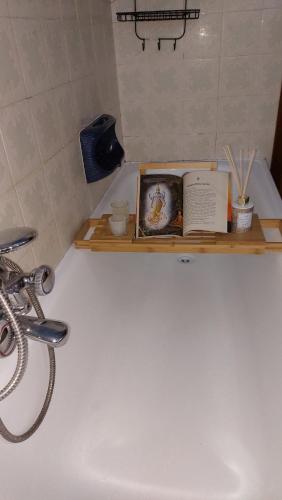 a book sitting on a shelf next to a bath tub at Casa vacanza PASsaggio in Como