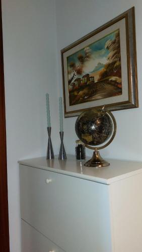 a white cabinet with a painting and vases on it at Casa vacanza PASsaggio in Como