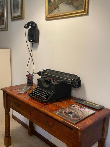a black typewriter sitting on a wooden table at Casa vacanza PASsaggio in Como