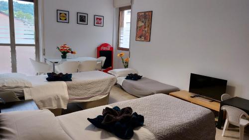 a room with three beds and a table with a television at Casa vacanza PASsaggio in Como