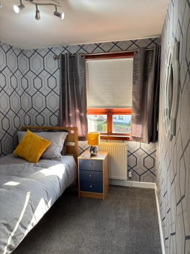 ein Schlafzimmer mit einem Bett und einem Fenster in der Unterkunft Forbela House in Fort William