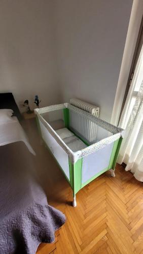 a green and white crib in a room at Casa vacanza PASsaggio in Como