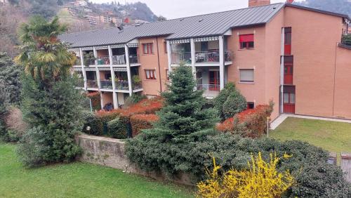 an apartment building with trees and bushes in front of it at Casa vacanza PASsaggio in Como