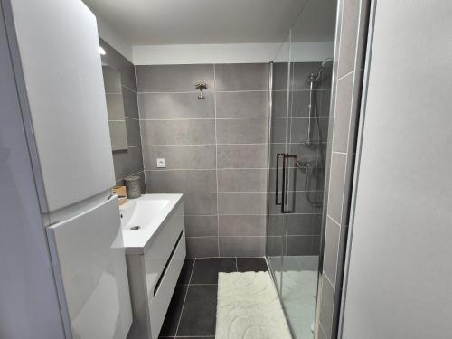 une salle de bain avec douche et lavabo dans l'établissement T2 neuf avec sa magnifique vue mer sur la baie de Bandol, à Bandol