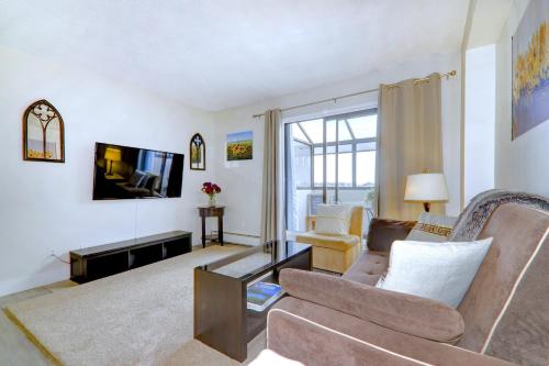 a living room with a couch and a tv at Spacious Top Floor at Stampede w Free Parking and AC in Calgary