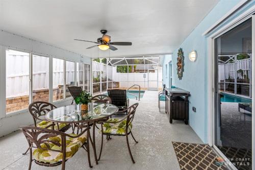 a balcony with a table and chairs and a pool at Dog Friendly and STEPS from the Ocean! Big Beach House with Pool, BBQ & Garage in Chicken Island