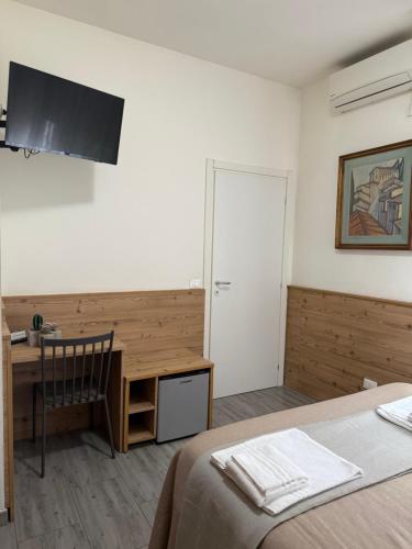 1 dormitorio con escritorio, 1 cama y 1 mesa en Affittacamere Casa Mia, en Verona