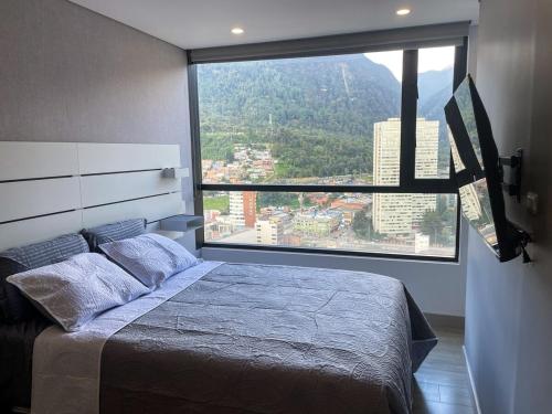 a bedroom with a bed and a large window at Nice apartment in downtown Bogotá in Bogotá