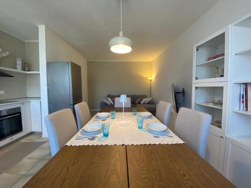 a dining room with a table with chairs and a kitchen at Monticella Haus Apartment in San Vendemiano