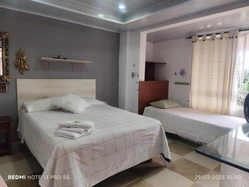 a bedroom with two beds and a window at Casa hotel villadiana in Armenia