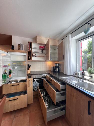 a kitchen with wooden cabinets and a sink at Hasenchalet Ruhpolding, familienfreundlich, Badewanne, Chiemgau-Karte inklusive in Ruhpolding