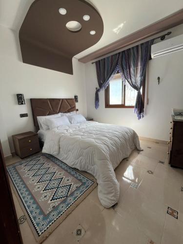 a bedroom with a large bed with a rug on the floor at Dar RADI Appart Terrace in Chefchaouen