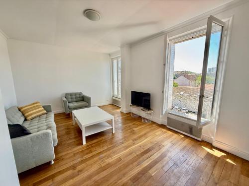 un salon avec un canapé et une table dans l'établissement Charmant appartement proche Paris, à Villeneuve-Saint-Georges