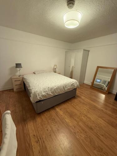 a bedroom with a bed and a mirror at Ibrahim's House in Chigwell