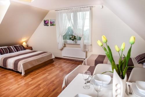 a small bedroom with a bed and a table and chairs at Villa Marta in Augustów