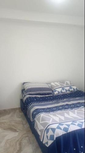 a bed with blue and white sheets in a room at Apto en Flandes - Tolima, tu oasis de tranquilidad y serenidad in Flandes