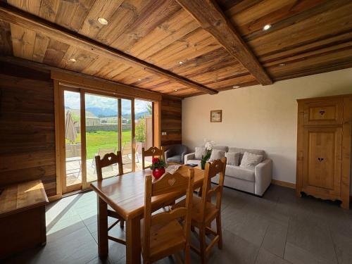 a dining room with a table and a couch at Gîte Balnéo Au Coeur des Alpes in Taninges