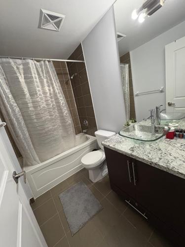 a bathroom with a toilet and a tub and a sink at Cozy Ensuite private room homestay in Mississauga