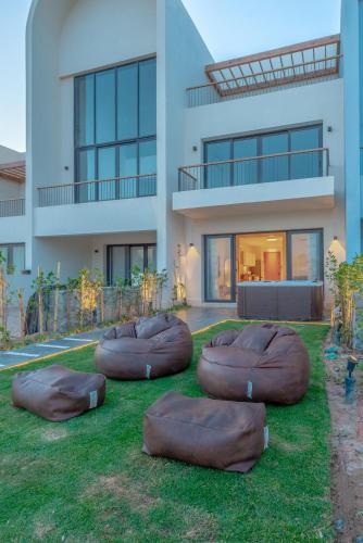 a house with brown bean bags on the lawn at Chic 1 BR with private jacuzzi in Banī Ghālib