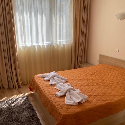 a bedroom with a bed with towels on it at Тристаен апартамент в затворен комплекс in Chernomorets