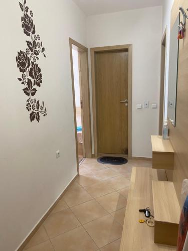 a living room with a door and a tile floor at Тристаен апартамент в затворен комплекс in Chernomorets