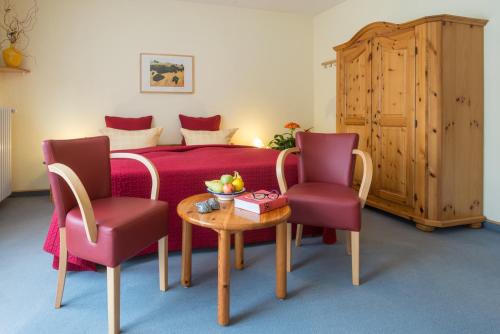 巴特布賴西希的住宿－Hotel Fontana - ADULTS ONLY，一间卧室配有一张床、两把椅子和一张桌子