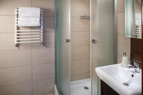 a bathroom with a white sink and a shower at Villa Marta in Augustów