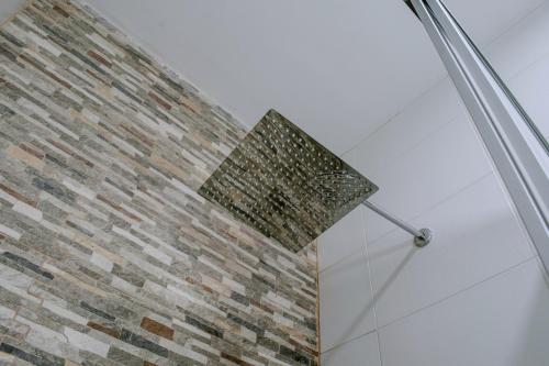 a brick wall in a shower with a shower head at DEPARTAMENTO AMOBLADO in Tacna