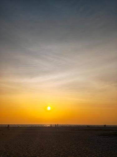 a sunset on a beach with the sun in the sky at JeeHaa Homestay in Alleppey