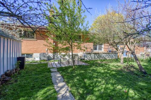 a yard with trees in front of a brick building at Bright & Modern 1 bedroom unit! in Guelph