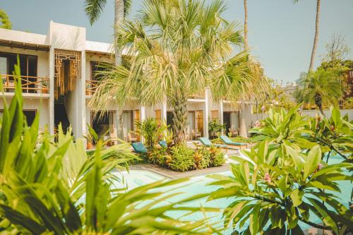 a resort with palm trees and a swimming pool at Bidmont Villa & Spa - Luxury Wellness Retreat in Puerto Escondido