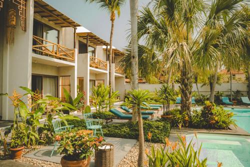 a resort with a pool and palm trees and plants at Bidmont Villa & Spa - Luxury Wellness Retreat in Puerto Escondido