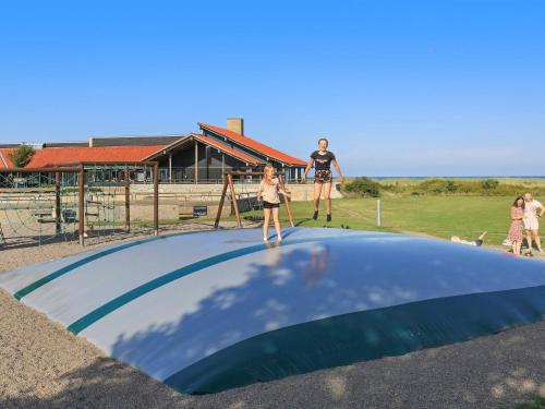 a group of people standing on top of a trampoline at 6 person holiday home on a holiday park in Sæby in Sæby