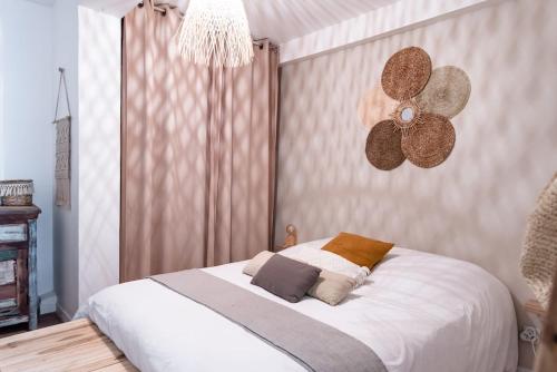 - une chambre avec un lit blanc et un ventilateur dans l'établissement Le Cocon au centre d'Arcachon, plage à pied, à Arcachon