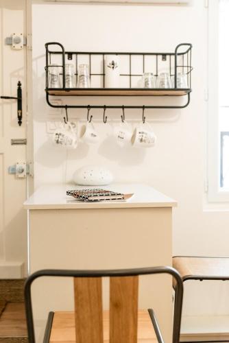 une cuisine avec un comptoir blanc et une étagère dans l'établissement Le Cocon au centre d'Arcachon, plage à pied, à Arcachon