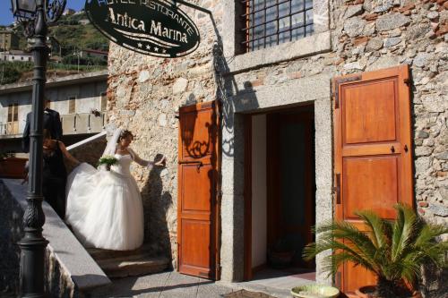 a bride and groom walking out of a building at Hotel Ristorante Antica Marina in Nicotera Marina