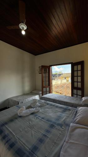 a large bed in a room with a large window at Casa do Mar Inn Paraty in Paraty