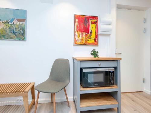 a living room with a chair and a microwave at 2 person holiday park home in Ringkøbing in Ringkøbing