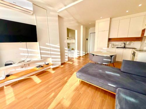 a large living room with a couch and a kitchen at Luxury apartment - parking, pool and beach access in Vlorë