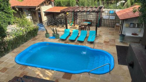 a large blue tub sitting on a patio with chairs at Pousada Casa Do Angelo in Jericoacoara