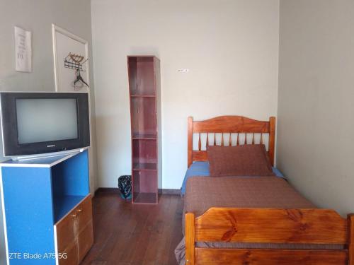 a small bedroom with a bed and a tv at Hostal Puerto Lounge in Valparaíso